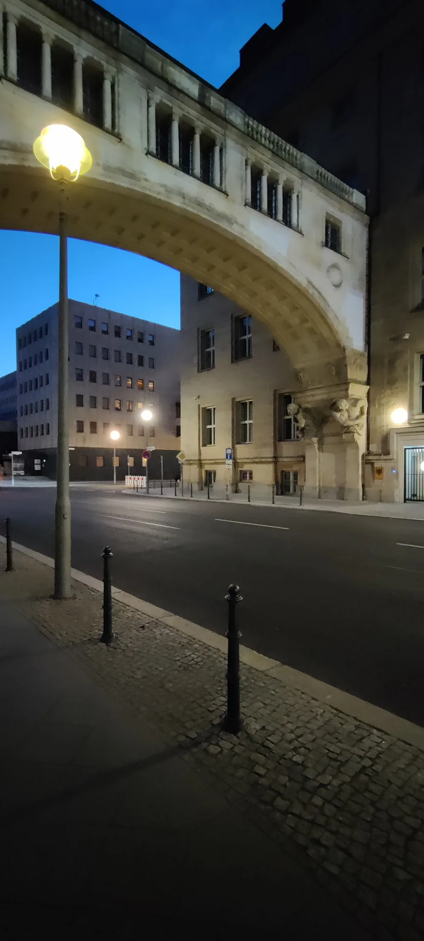 Photo d'une arche à décor projeté, reliant deux bâtiments au-dessus d'une rue déserte