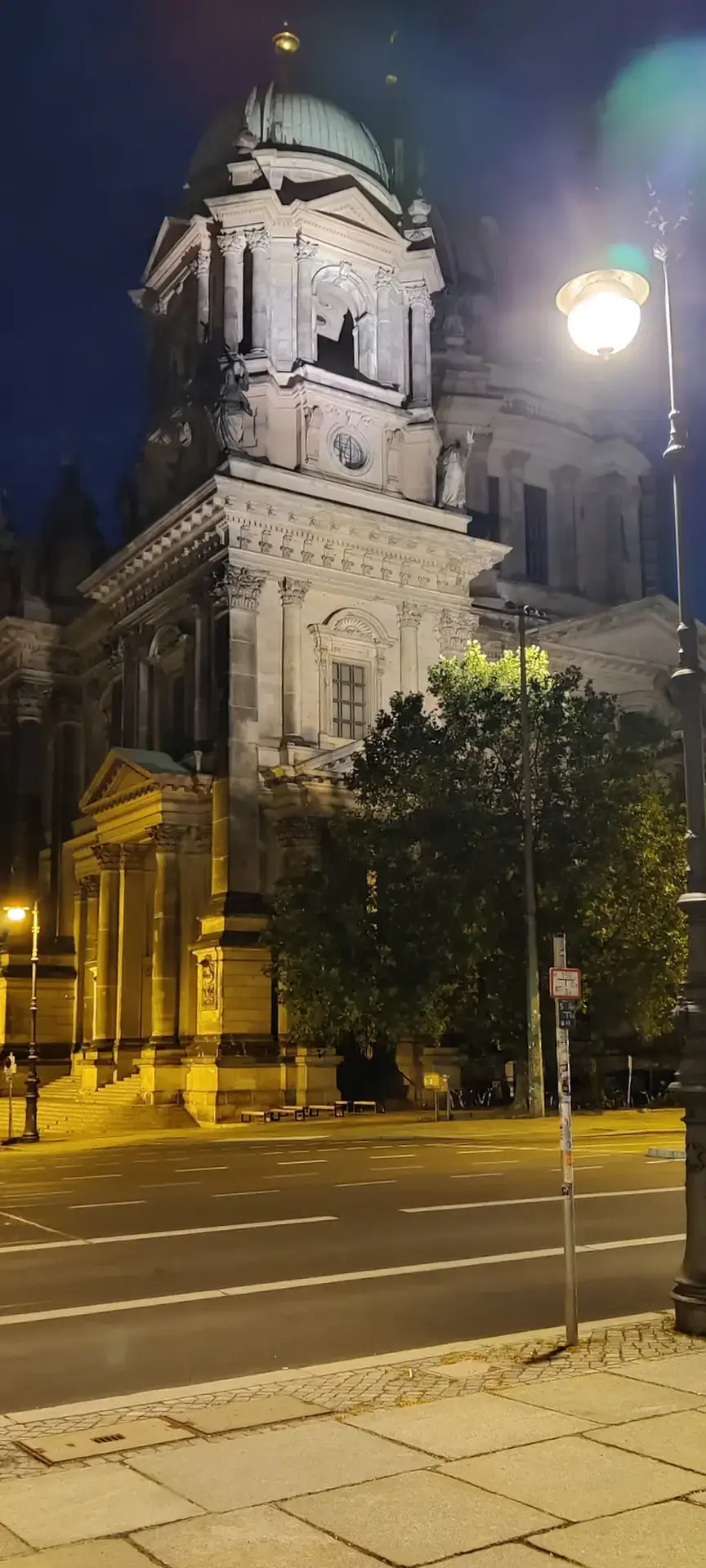 Photo de la tour d'angle de la cathédrale de Berlin dans la nuit, un lampadaire allumé au premier plan