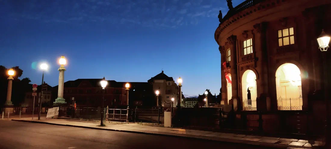 Photo de la rotonde du musée de Bode éclairée dans la nuit, la rue et ses lampadaires