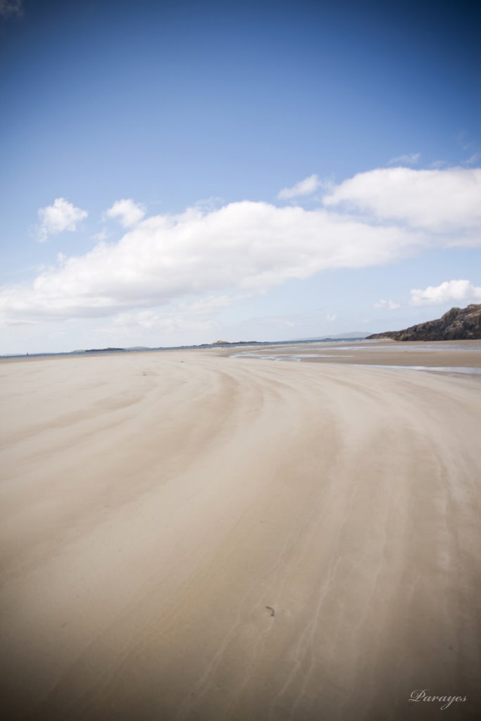 Les lignes du sable amènent la plage à rencontrer le ciel