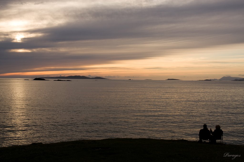 La falaise offre à un couple un coucher de soleil au bruit des vagues
